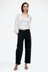 Musculosa blanca con breteles anchos, cierre oculto lateral y escote redondeado pronunciado adelante y atrás. Modelo con pinzas en el busto y cintura entallada con costuras visibles adelante y atrás. Parte superior forrada.