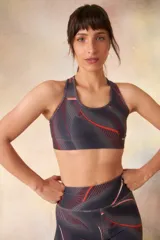 Top deportivo negro con estampado camuflado en tonos grises, breteles anchos y espalda deportiva.