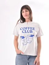Remera blanca con estampado frontal de dos vasos de café con la frase "Coffee Club" en color azul.