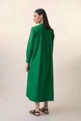 Vestido largo verde esmeralda de algodón, con cuello mao, mangas largas con puños abotonados, pechera con botones y corte evasé.