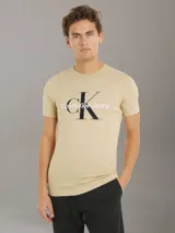 Remera slim de algodón regenerativo color beige, con cuello redondo y monograma de Calvin Klein estampado en el pecho.