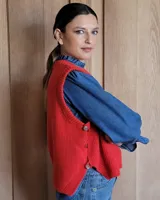 Chaleco de punto marrón con cuello redondo y sisas amplias.