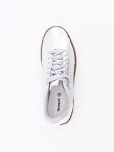 Zapatillas plateadas con suela marrón.