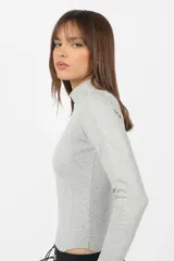 Body manga larga color beige, de punto roma, con cuello alto y mitones en los puños.