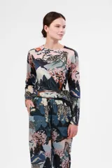 Sweater de cashmere con estampado de leopardos de las nieves en un paisaje montañoso con árboles de cerezo en flor.