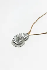 Collar con cordón marrón y dije de caracol plateado.