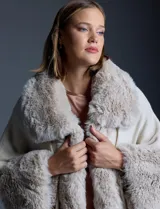 Ruana tejida color crema de la marca Adrienne Vittadini, con cuello, delantera y puños con aplique en símil piel. Delantera con abertura central y botón trenca.