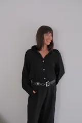 Camisa negra de crepé con cuello clásico y mangas largas.