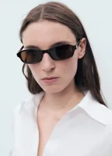 Camisa blanca oversize de lino, con cuello camisero, manga larga con puños abotonados y cierre frontal con botones.