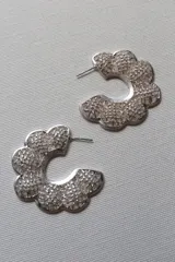 Aros plateados con forma de flor calada.