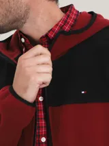Campera con capucha Tommy Hilfiger, color rojo y negro, con cierre de cremallera, bolsillos laterales con cierre y logo de la marca bordado en el pecho.