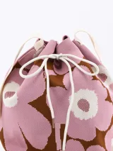 Bolso bandolera tipo bucket con estampado de flores en blanco y negro, con ajuste superior de cordón y correa larga de hombro negra.