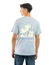 Remera celeste con estampado circular en el pecho, con texto en verde y negro.