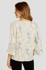 Blusa de viscosa estampada en tonos celeste y blanco, con cuello redondo y mangas 3/4 con volados.