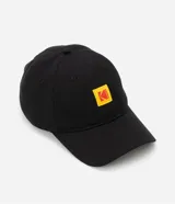 Gorra negra de sarga de algodón con visera curva, hebilla ajustable y logo de Kodak bordado en amarillo y rojo.