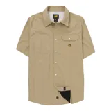 Camisa de manga corta marca Caterpillar en color beige, de estilo western con botones a presión tipo perla. Confeccionada en tejido técnico elástico con protección solar UPF 50+, cuenta con dos bolsillos frontales con solapa, ventilación trasera con malla y paño de microfibra oculto para limpieza de lentes.