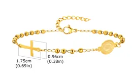 Set de tres pulseras doradas con dijes religiosos: una de cuentas redondas con cruz grande, otra con cuentas negras y dijes de medallas, y otra con cuentas pequeñas y cruz pequeña.