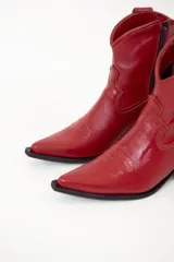 Bota texana corta de cuero color rojo, con punta fina, caña baja y taco cuadrado.