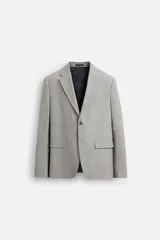 Blazer regular fit color gris claro confeccionado en tejido con lana. Tiene cuello con solapas de muesca, manga larga con puño abotonado, bolsillo de vivo en el pecho, bolsillos de solapa en la cadera, bolsillo interior, aberturas en la espalda y cierre frontal con botones.