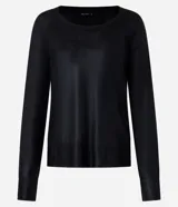 Blusa negra de punto liviano con escote redondo, manga larga y sisa raglán. Tiene una malla con lámina metálica.