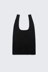 Bolso tipo shopper negro con asas cortas. Estampado frontal con el logo de Zara, la leyenda "A Coruña Established 1975" y la dirección "Rúa Juan Flórez 64-66" en color blanco.