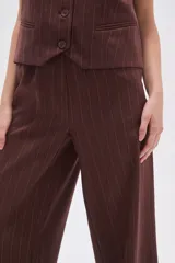 Pantalón ancho de poliéster negro con rayas verticales blancas, de calce medio y bolsillos laterales.