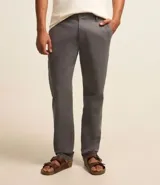 Pantalón de vestir color marrón, de corte recto, con bolsillos laterales y traseros. Se ajusta a la cintura con cinturón de cuero marrón.