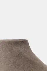 Top sin mangas, color marrón topo, con cuello alto y corte recto. Presenta un tejido de punto fino y mangas sisa con caída.