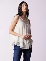Blusa de gasa color blanco, marca Liv Los Ángeles, con breteles trenzados y diseño de capas en encaje y gasa.