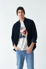 Camisa de pana color verde militar, de corte regular, con cuello clásico y cierre frontal con botones.