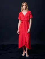 Vestido largo de gasa color rojo, con escote en V, mangas cortas con volados, cintura elastizada con lazo de ajuste y ruedo asimétrico con volados. Tiene forro interno a tono.