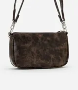 Cartera baguette pequeña color marrón con efecto desgastado, cierre de cremallera, asa larga desmontable y detalle de cadena plateada.
