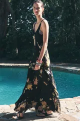 Vestido largo negro con estampado floral en tonos naranja y blanco, escote en V y breteles finos.