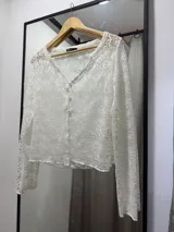 Saco calado negro con mangas largas y botones frontales.