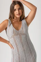 Vestido midi tejido al crochet color gris plata, con breteles finos y flecos en el ruedo.