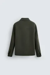 Sobrecamisa color beige de corte relaxed fit, con cuello solapa, manga larga con puños abotonados, bolsillos de plastrón con solapa en el pecho y bolsillos de vivo en la cadera. Cierre frontal con botones.