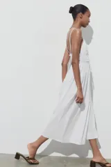 Vestido midi blanco de popelín con escote pico pronunciado, tirantes finos ajustables con cordones y detalle de frunces en la cintura.