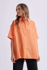 Camisa naranja fluida de manga corta con cuello clásico y cierre con botones.