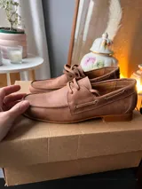 Mocasines de cuero negro con cordones finos y suela plana.
