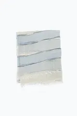 Pashmina celeste con rayas horizontales en tonos de blanco, gris y negro, con flecos en los extremos.