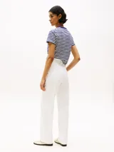 Pantalón chino blanco de algodón, corte recto, con cierre de cremallera y botón, bolsillos laterales ribeteados y bolsillos traseros de ojal.