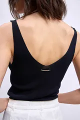 Pantalón de denim color crudo, corte ancho y tiro alto, con grandes calados florales bordados en contraste a lo largo de ambas piernas.