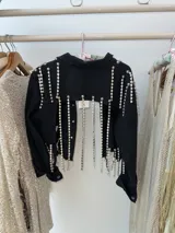 Campera cropped de jean negra con tiras de strass plateado y botones plateados al frente.