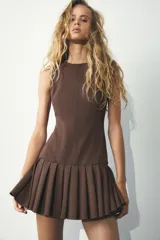 Vestido marrón sin mangas con cuello redondo y falda con pliegues.