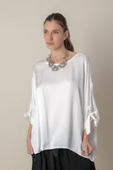 Blusa italiana color blanco, de calce holgado y mangas 3/4 con lazos.
