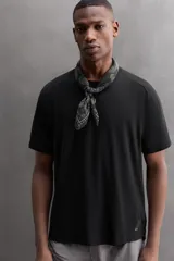 Camiseta deportiva verde militar confeccionada en tejido estructurado, ligero y elástico. Tiene cuello redondo, manga corta y bajo con aberturas laterales. Incluye logo estampado en el bajo.