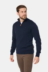 Sweater de punto fino color beige, con cuello alto y medio cierre frontal con cremallera.