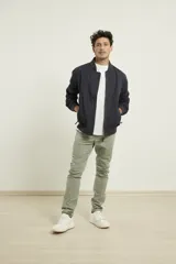 Campera bomber de color negro con puños tejidos y cierres metálicos, confeccionada en 100% algodón.