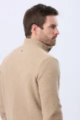 Buzo tejido color beige con textura, cuello alto con botones y manga larga.