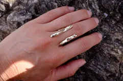 Anillo plateado con diseño abstracto y abierto, realizado en alpaca.